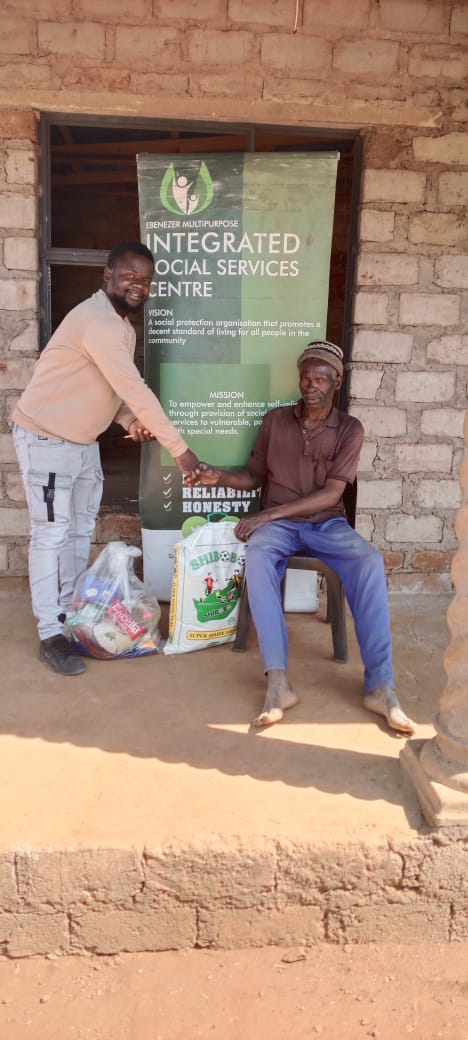 EMISSC representative handing a food parcel to an elder